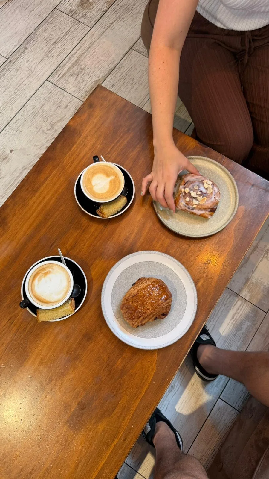 Dos cafés y bollería compartidos alrededor de una mesa